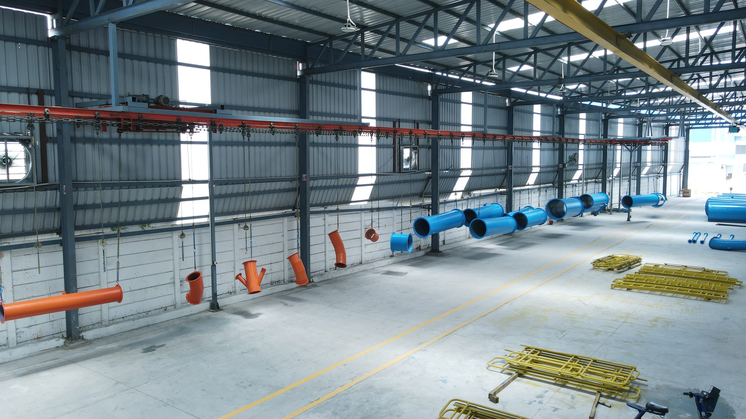 Painted industrial duct components moving through the TECHFLOW conveyorized painting area